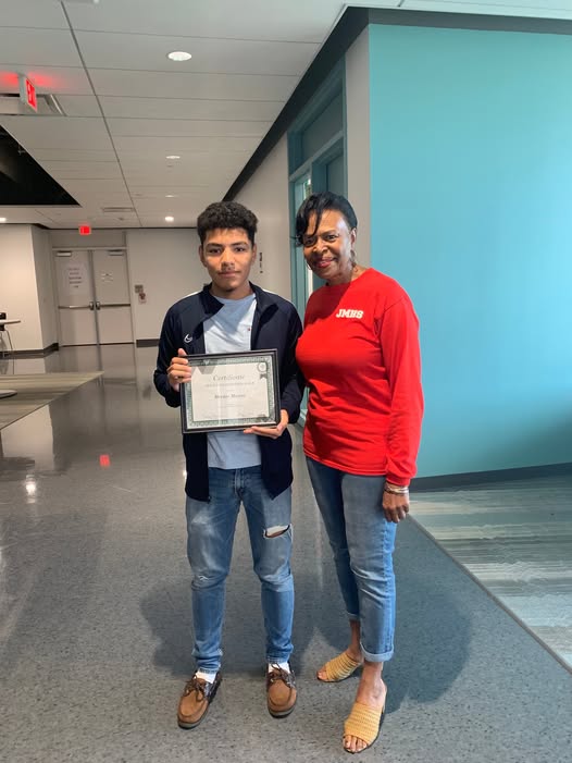 Marilyn celebrating a student receiving a certificate of achievement
